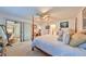 Sunlit primary bedroom featuring a four poster bed, ceiling fan and access to the outdoor living space at 1417 Langley Dr, Sun City Center, FL 33573