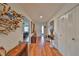Bright hallway with wood floors, closet, and art leading into a bedroom with ceiling fan at 1417 Langley Dr, Sun City Center, FL 33573