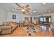 Inviting living room featuring wood floors, ceiling fan, and an array of comfortable furniture at 1417 Langley Dr, Sun City Center, FL 33573