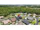 Beautiful aerial view of neighborhood homes and a blue house featuring a pool and lush green trees at 1741 Beaconsfield Dr, Wesley Chapel, FL 33543