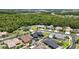 Beautiful aerial view of neighborhood homes and a blue house featuring a pool and lush green trees at 1741 Beaconsfield Dr, Wesley Chapel, FL 33543