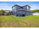 View of the backyard of the house which shows the pool and big lawn at 1741 Beaconsfield Dr, Wesley Chapel, FL 33543