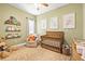 Charming Bedroom with a wooden crib, whimsical decor, and a comfortable armchair at 1741 Beaconsfield Dr, Wesley Chapel, FL 33543