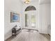 Chic entryway featuring light tile floors, a modern bench, and a striking arched glass double door at 1741 Beaconsfield Dr, Wesley Chapel, FL 33543