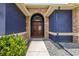 Close up of an arched entryway with stone accents leading to a striking, double front door at 1741 Beaconsfield Dr, Wesley Chapel, FL 33543