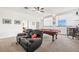 Open concept game room with a pool table, comfortable seating, and a bar area at 1741 Beaconsfield Dr, Wesley Chapel, FL 33543