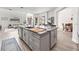 Open-concept kitchen features a large island, granite countertops, stainless steel sink, and breakfast bar at 1741 Beaconsfield Dr, Wesley Chapel, FL 33543
