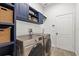 Convenient laundry room with blue cabinetry, woven baskets, and modern appliances at 1741 Beaconsfield Dr, Wesley Chapel, FL 33543