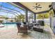 Inviting screened patio with comfortable seating, a fire pit, and a view of the pool at 1741 Beaconsfield Dr, Wesley Chapel, FL 33543