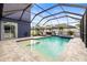 Beautifully screened pool area with a spa, a seating area, and a well-maintained deck at 1741 Beaconsfield Dr, Wesley Chapel, FL 33543