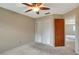 Bedroom with carpet floors, ceiling fan, and a closet with bi-fold doors at 1808 Sawhorse Ct, Lutz, FL 33559