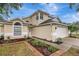 Charming home with a well-manicured lawn, mature landscaping, and a brick-lined garden bed at 1808 Sawhorse Ct, Lutz, FL 33559