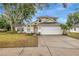 Charming two-story home with a well-manicured lawn, inviting walkway, and attached two-car garage at 1808 Sawhorse Ct, Lutz, FL 33559