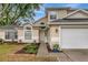 Close up view of the home's entrance featuring a well-landscaped garden bed and neutral-toned exterior at 1808 Sawhorse Ct, Lutz, FL 33559