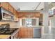 Well-equipped kitchen featuring stainless steel appliances, granite countertops, and wooden cabinets with outdoor view at 1808 Sawhorse Ct, Lutz, FL 33559
