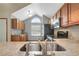 Well-lit kitchen featuring wood cabinetry, stainless steel appliances, and a large sink area at 1808 Sawhorse Ct, Lutz, FL 33559