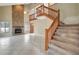 Bright living room with tiled floors, stone fireplace, and wooden staircase leading to the second floor at 1808 Sawhorse Ct, Lutz, FL 33559