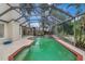 Exterior pool view of a screened-in pool with a deck, lush landscaping, and clear blue skies at 1808 Sawhorse Ct, Lutz, FL 33559