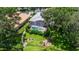 Aerial of backyard featuring a screened pool, lush landscaping and decorative rocks and black iron fence at 1936 Floresta View Dr, Tampa, FL 33618