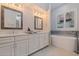 Bathroom featuring double sinks, soaking tub and decorative mirrors at 1936 Floresta View Dr, Tampa, FL 33618