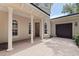 Home's exterior featuring a portico with columns and brick courtyard leading to a three car garage at 1936 Floresta View Dr, Tampa, FL 33618