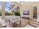 Cozy outdoor living area with comfortable seating, a TV, and a view of the pool at 1936 Floresta View Dr, Tampa, FL 33618