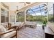 This screened-in lanai features stone tile flooring, ceiling fans and plenty of seating at 1936 Floresta View Dr, Tampa, FL 33618