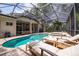 A large screened-in pool with hot tub and several lounge chairs offers backyard relaxation at 1936 Floresta View Dr, Tampa, FL 33618