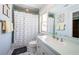 Bathroom with mint green tile, white fixtures, and a shower with a polka dot curtain at 1988 Carolina Ne Cir, St Petersburg, FL 33703