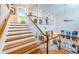 Grand two-story foyer with wooden staircase and railing, creating a welcoming entrance with an open layout at 1988 Carolina Ne Cir, St Petersburg, FL 33703