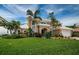 Lush landscaping and mature palm trees frame this beautiful home, with a well-manicured lawn at 1988 Carolina Ne Cir, St Petersburg, FL 33703