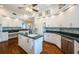 Large kitchen with an island, white cabinets, dark countertops, and stainless appliances at 1988 Carolina Ne Cir, St Petersburg, FL 33703