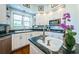 Well-lit kitchen with white cabinets, dark countertops, and stylish backsplash tiles at 1988 Carolina Ne Cir, St Petersburg, FL 33703