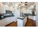 Bright kitchen boasts white cabinetry, granite counters, stainless appliances, and a center island with sink at 1988 Carolina Ne Cir, St Petersburg, FL 33703