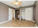 This bedroom has wood-look flooring, a ceiling fan, and a closet with sliding doors at 2035 Nolan Dr, Dunedin, FL 34698