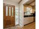 Entryway with wooden door, tile flooring, and beams is adjacent to the kitchen with tile flooring at 2035 Nolan Dr, Dunedin, FL 34698