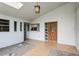 View of the front porch, decorative rocks, walkway, and the wood paneled front door, plus an exterior light at 2035 Nolan Dr, Dunedin, FL 34698