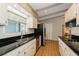 Traditional kitchen featuring black countertops, white cabinets, stainless steel appliances, and a beamed ceiling at 2035 Nolan Dr, Dunedin, FL 34698