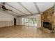 Open living space with wood-look flooring, exposed wood beams, and sliding glass doors to screened patio at 2035 Nolan Dr, Dunedin, FL 34698