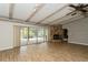 Open living space with wood-look flooring, exposed wood beams, and sliding glass doors to screened patio at 2035 Nolan Dr, Dunedin, FL 34698