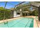 The large screened-in pool area features a covered patio and lush landscaping at 2035 Nolan Dr, Dunedin, FL 34698