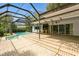 A stunning screened-in pool and patio area with a built-in outdoor kitchen perfect for entertaining at 2035 Nolan Dr, Dunedin, FL 34698
