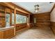 Wood-paneled sun room with floor to ceiling windows and built in shelving at 2035 Nolan Dr, Dunedin, FL 34698