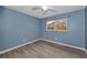 This bedroom features modern gray flooring, a window and a ceiling fan at 2063 Ridgecrest Dr, Dunedin, FL 34698