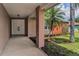 Covered front porch leading to a double-door entrance, complemented by tropical landscaping at 2063 Ridgecrest Dr, Dunedin, FL 34698