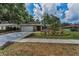 Inviting single-story home featuring a two-car garage, stone accents, and tropical landscaping at 2063 Ridgecrest Dr, Dunedin, FL 34698