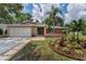 Single-story home with lush landscaping, stone accents, and a well-manicured front yard at 2063 Ridgecrest Dr, Dunedin, FL 34698