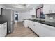 Kitchen featuring modern appliances, white cabinets, and a view of the sink with a tiled backsplash at 2063 Ridgecrest Dr, Dunedin, FL 34698