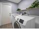 Laundry room features a washer and dryer, shelf with decorative plants at 2063 Ridgecrest Dr, Dunedin, FL 34698