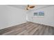 Bright main bedroom featuring a ceiling fan, wood-look floors, and a window with a backyard view at 2063 Ridgecrest Dr, Dunedin, FL 34698